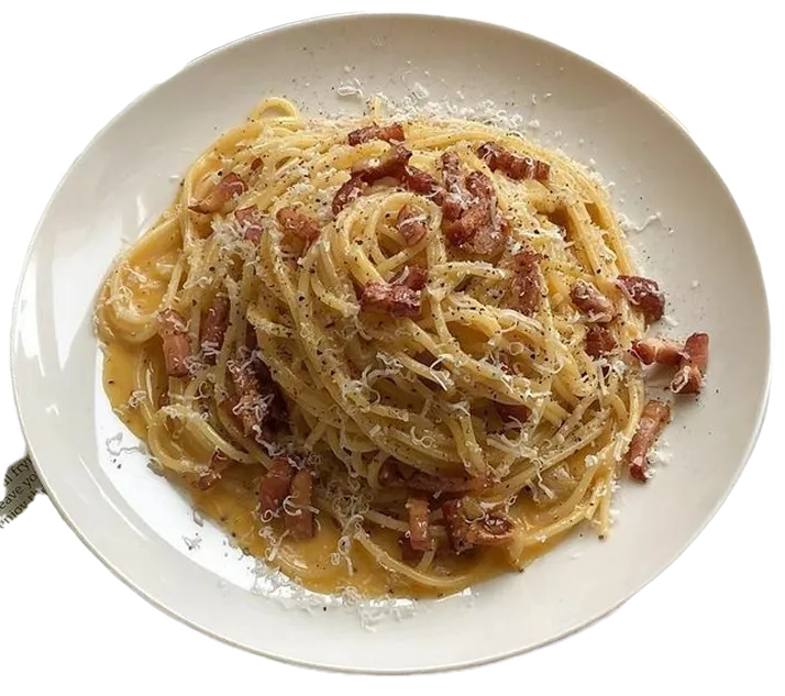 Spaghetti dish with bacon on a white plate