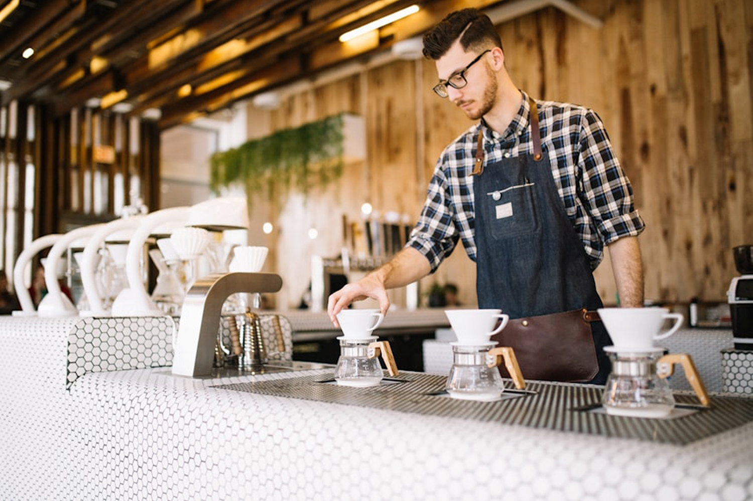 A guatemalan coffee shop and its store owner preparing dripped coffees. 