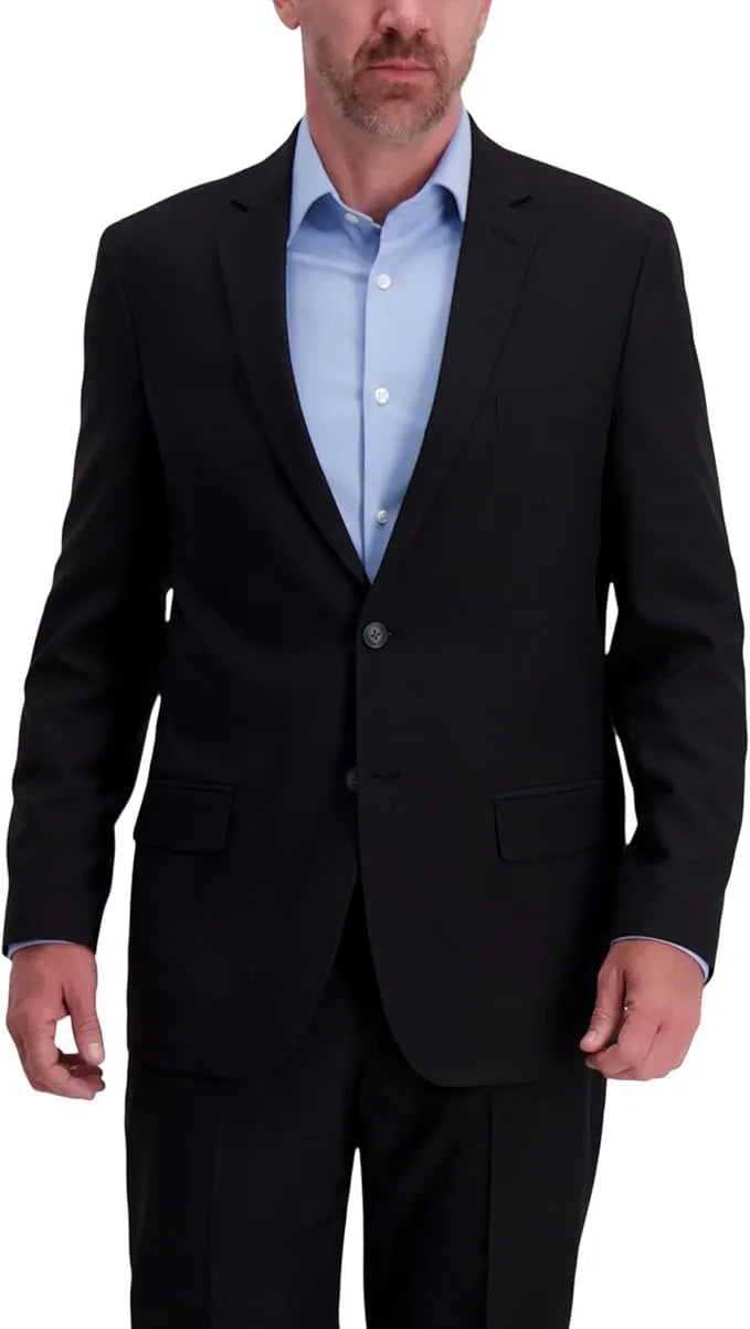 Man wearing a black suit jacket over a light blue shirt on a white background