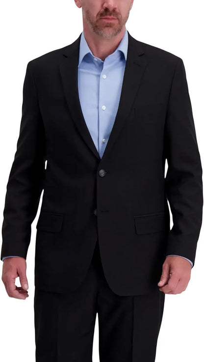 Man wearing a black suit jacket over a light blue shirt on a white background