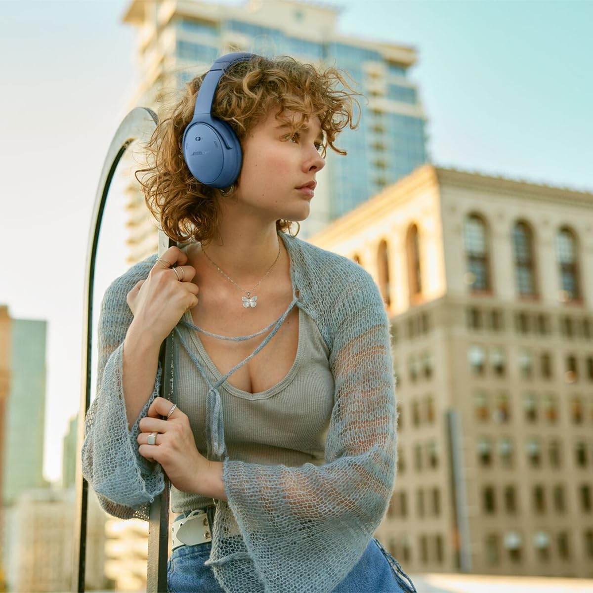 Woman wearing blue headphones in an urban setting