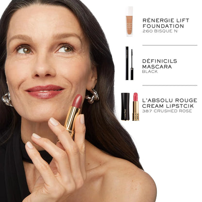 Woman applying lipstick with makeup products displayed on a white background