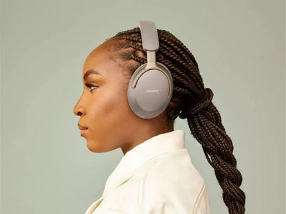 Woman wearing Bose headphones against a plain background
