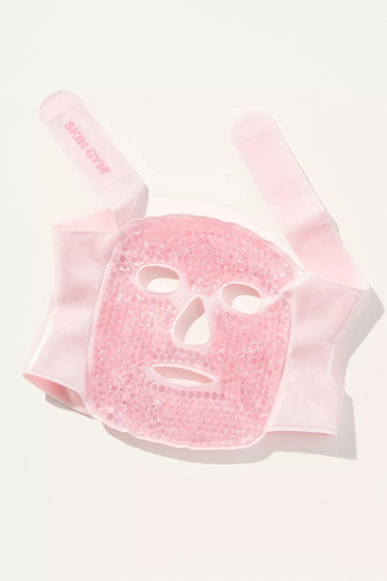 Pink face mask with a white face design on a white background