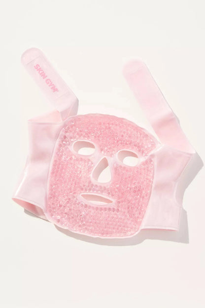 Pink face mask with a white face design on a white background