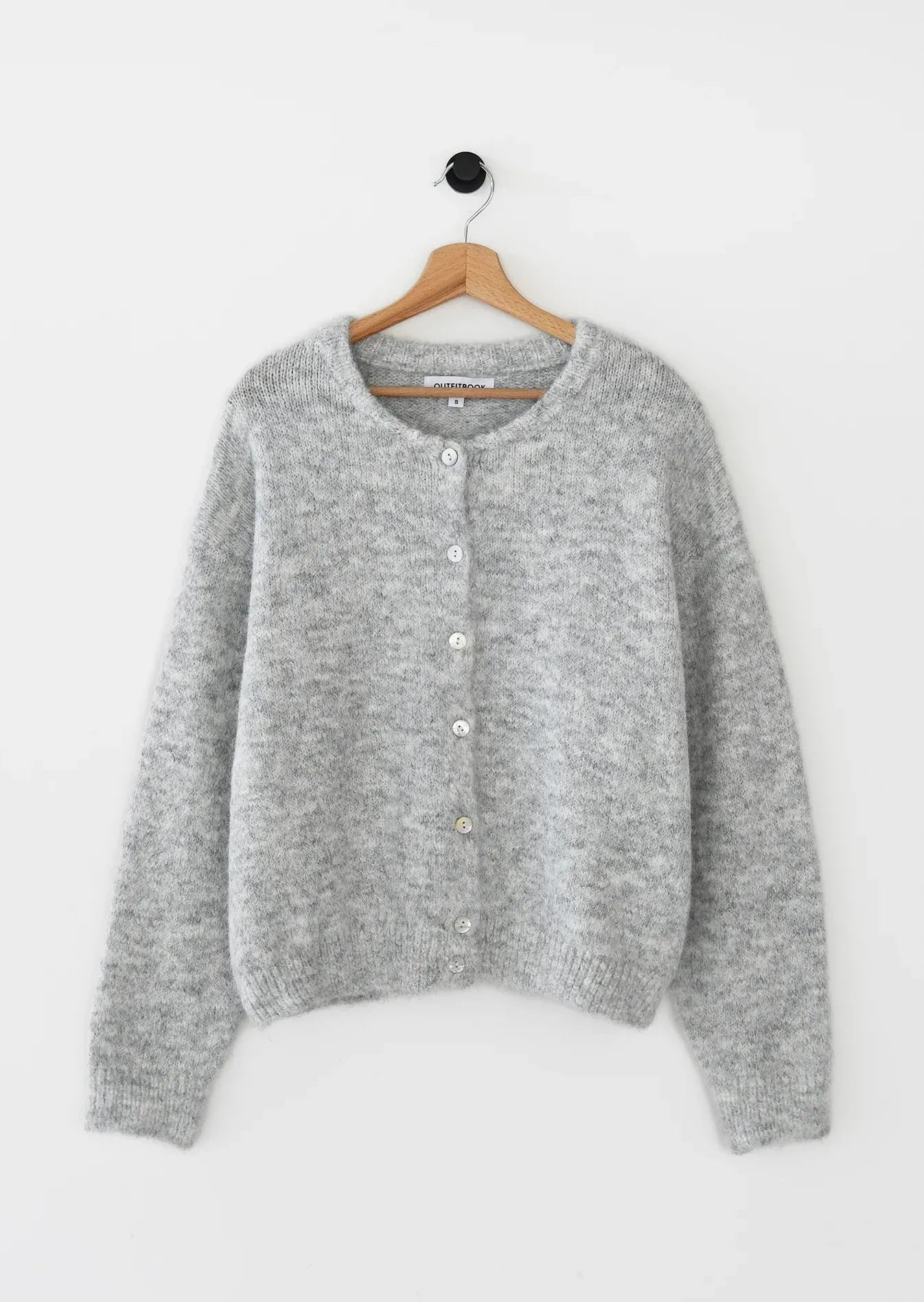 Gray cardigan on a hanger against a white background